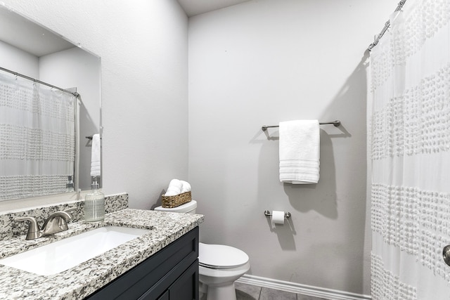 bathroom with toilet, vanity, and tile patterned flooring