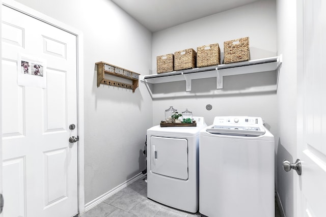 clothes washing area with separate washer and dryer and light tile patterned floors