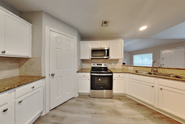 kitchen with tasteful backsplash, stainless steel appliances, light wood-type flooring, sink, and white cabinets