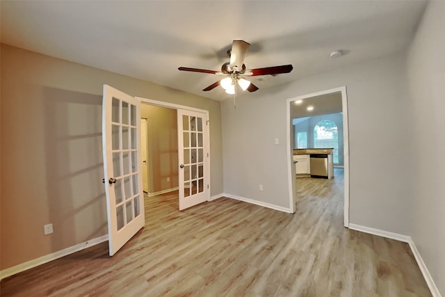 empty room featuring ceiling fan, french doors, and light hardwood / wood-style floors