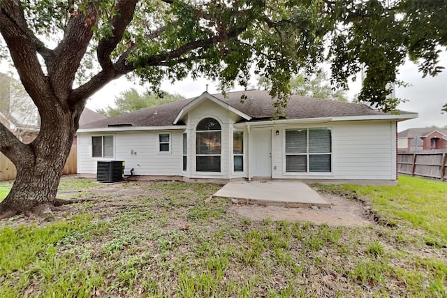 back of property with central air condition unit, a lawn, and a patio