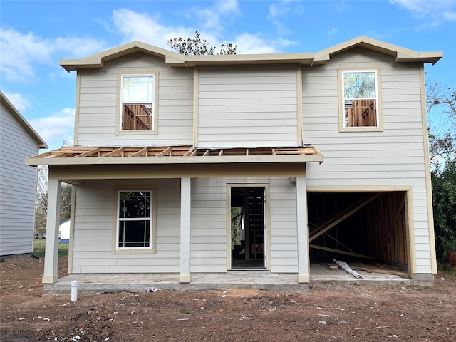 rear view of property featuring a garage