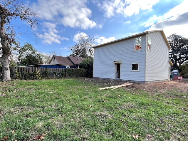 rear view of house featuring a yard