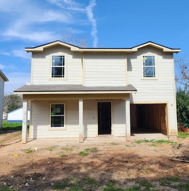 traditional-style home featuring a garage and covered porch