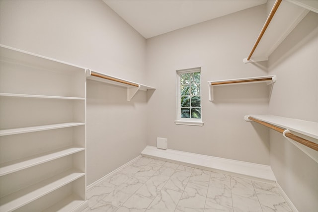 walk in closet with marble finish floor