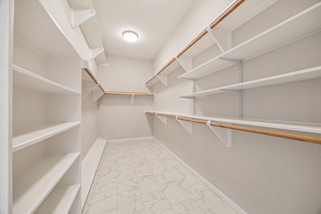 walk in closet with marble finish floor