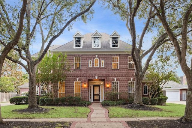 colonial home featuring a garage and a front yard