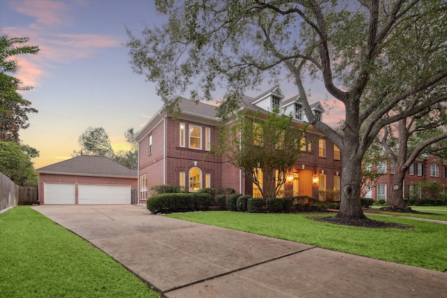 colonial inspired home with a garage and a yard