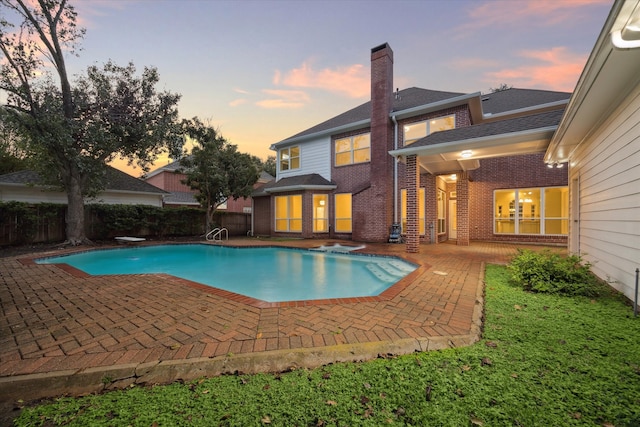 pool at dusk featuring a fenced in pool, a patio area, and fence