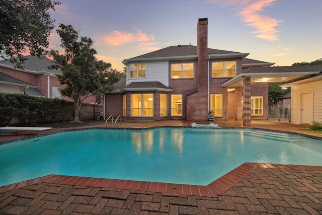 view of pool with fence, a diving board, a fenced in pool, and a patio