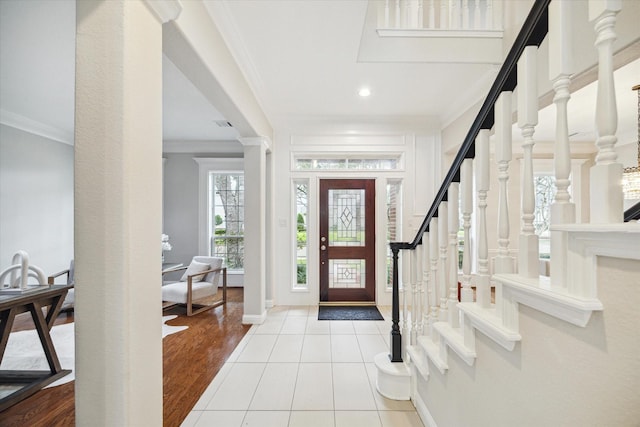 entryway with light tile patterned floors, ornamental molding, and baseboards