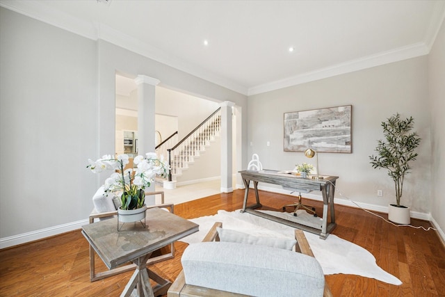 office space featuring ornamental molding, decorative columns, and wood finished floors