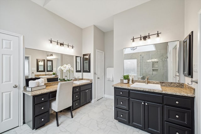 bathroom featuring marble finish floor, two vanities, a sink, and a shower stall