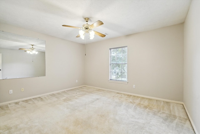 spare room featuring a textured ceiling, carpet, and ceiling fan