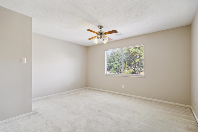 empty room with a textured ceiling, light carpet, and ceiling fan