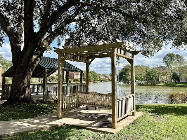 view of dock with a gazebo, a yard, a water view, and a pergola