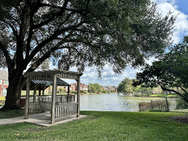 dock area featuring a pergola, a water view, and a lawn