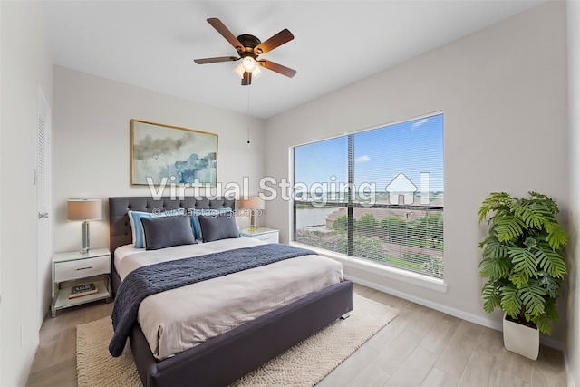 bedroom with light hardwood / wood-style floors and ceiling fan