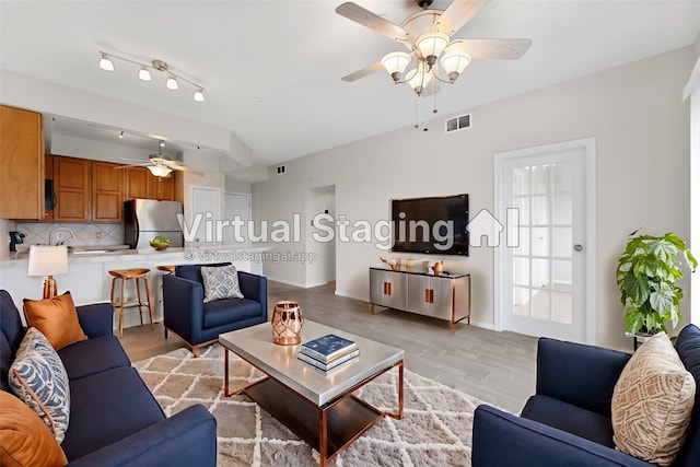 living room featuring ceiling fan and light hardwood / wood-style flooring