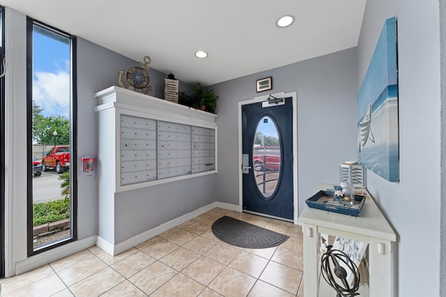 foyer featuring a mail area, a wealth of natural light, and light tile patterned floors