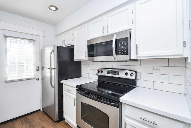 kitchen featuring white cabinetry, decorative backsplash, appliances with stainless steel finishes, and dark hardwood / wood-style flooring