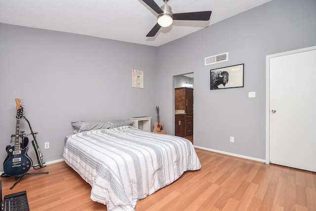 bedroom featuring ensuite bathroom, a textured ceiling, wood-type flooring, and ceiling fan