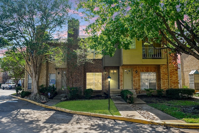 multi unit property featuring a balcony and a yard