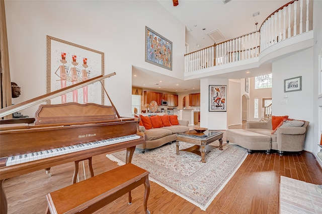 living room with light hardwood / wood-style flooring and a high ceiling