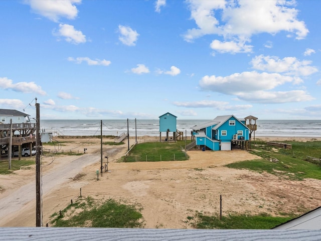 view of jungle gym featuring a water view and a view of the beach