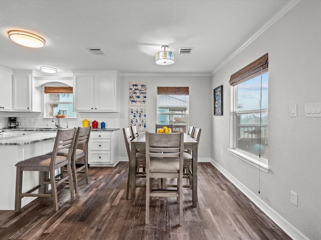 dining room with dark hardwood / wood-style flooring, plenty of natural light, and crown molding