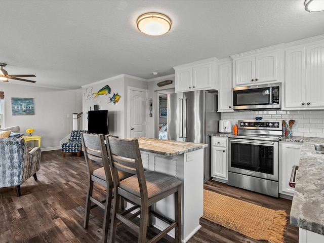 kitchen featuring appliances with stainless steel finishes, white cabinetry, and dark wood-type flooring