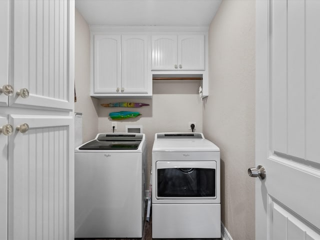 clothes washing area featuring cabinets and independent washer and dryer