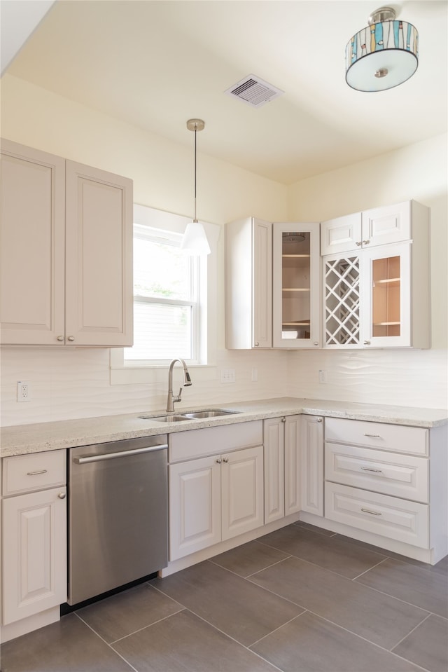 kitchen featuring tasteful backsplash, stainless steel dishwasher, decorative light fixtures, and white cabinets