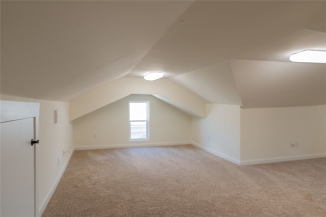 bonus room with light carpet and lofted ceiling