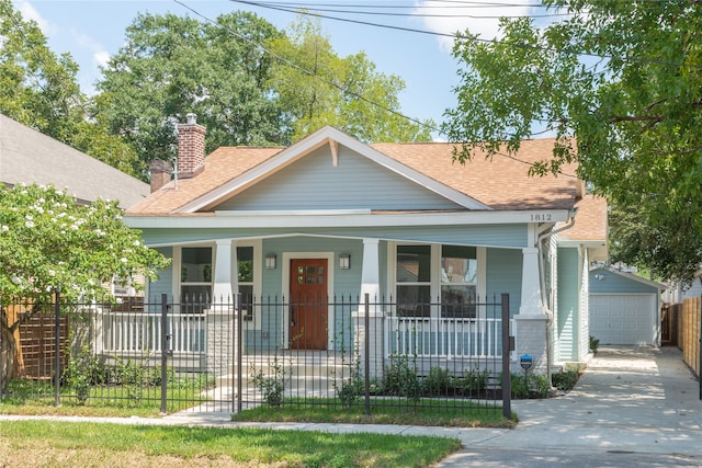 bungalow featuring a porch, a garage, and an outdoor structure