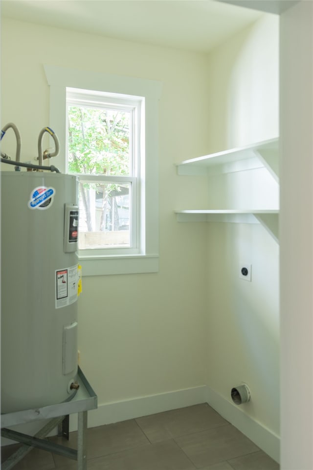 laundry area with electric water heater, tile patterned flooring, and electric dryer hookup