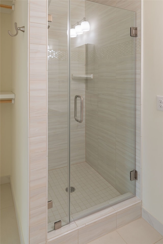 bathroom with tile patterned floors and a shower with shower door