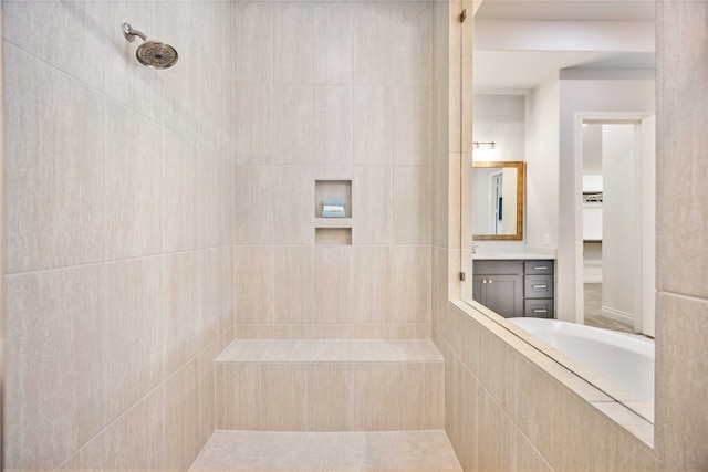 bathroom featuring a tile shower and vanity