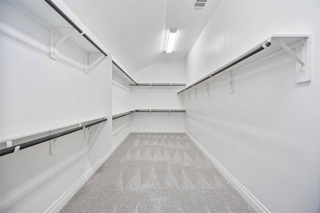 walk in closet featuring lofted ceiling and light carpet