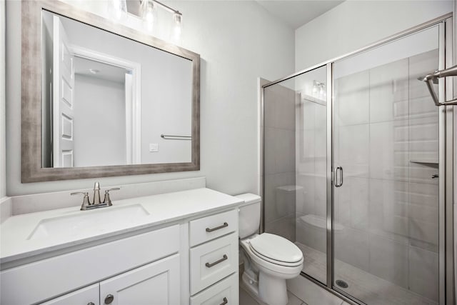 bathroom with vanity, toilet, and a shower with shower door