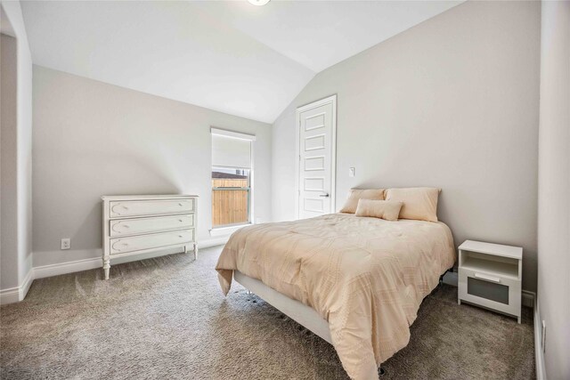 bedroom with vaulted ceiling and dark colored carpet