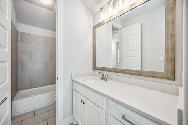 full bathroom featuring vanity, tiled shower / bath combo, and toilet