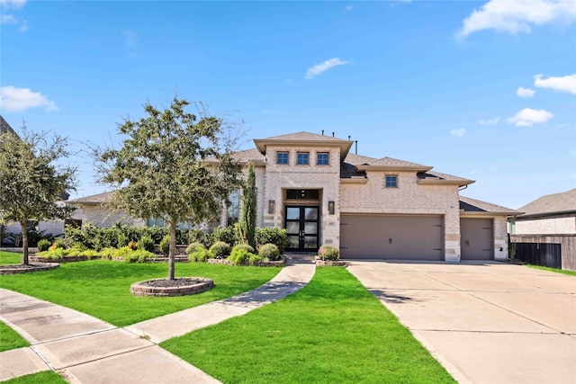 view of front facade featuring a garage, a front yard, and french doors