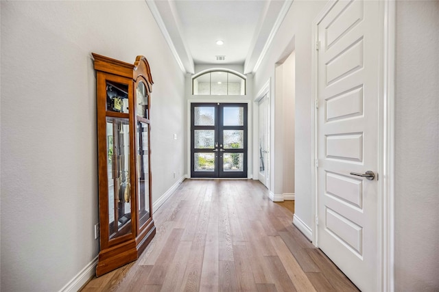 foyer entrance with french doors and light hardwood / wood-style flooring