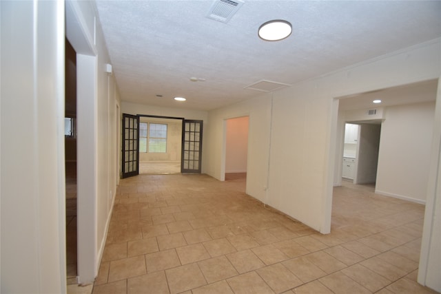 unfurnished room with a textured ceiling and light tile patterned floors