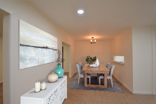 dining space featuring crown molding and tile patterned floors