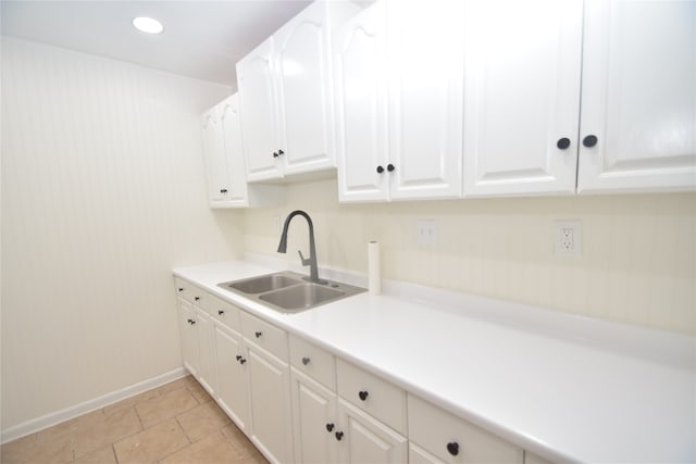 kitchen featuring white cabinets, light tile patterned flooring, and sink