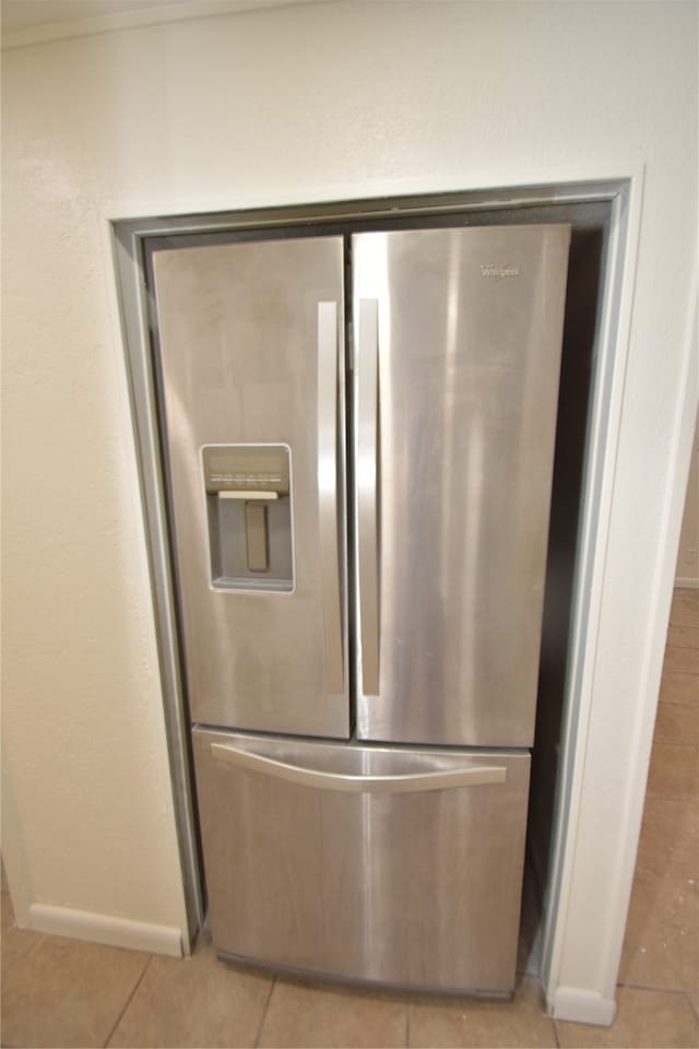 interior details with light tile patterned floors and stainless steel fridge