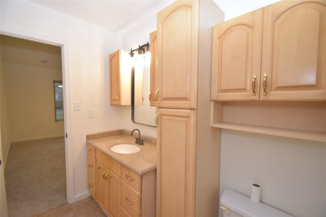 bathroom with toilet, vanity, and tile patterned floors