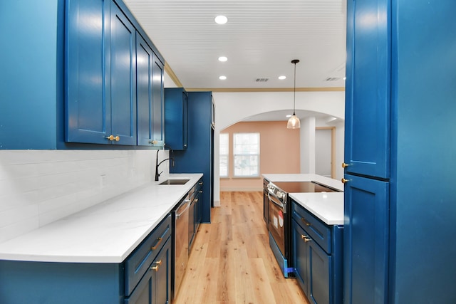 kitchen featuring blue cabinetry, appliances with stainless steel finishes, and hanging light fixtures